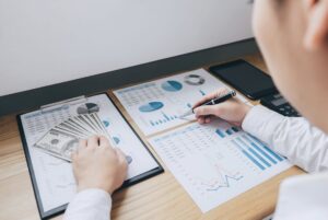A business owner reviewing complex financial growth charts and revenue reports to address the impact of negative retained earnings on his company's valuation